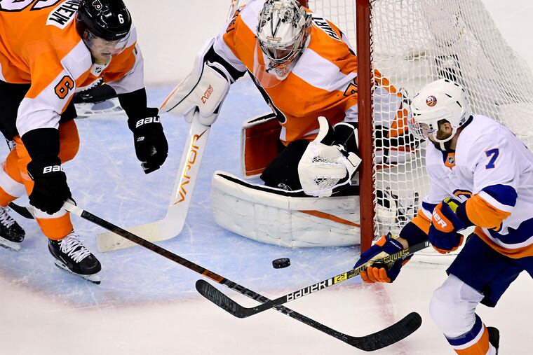 Flyers goaltender Carter Hart (79) makes a save as teammate Travis Sanheim (6) and New York Islanders right wing Jordan Eberle (7) vie for the rebound during first-period action in Toronto,