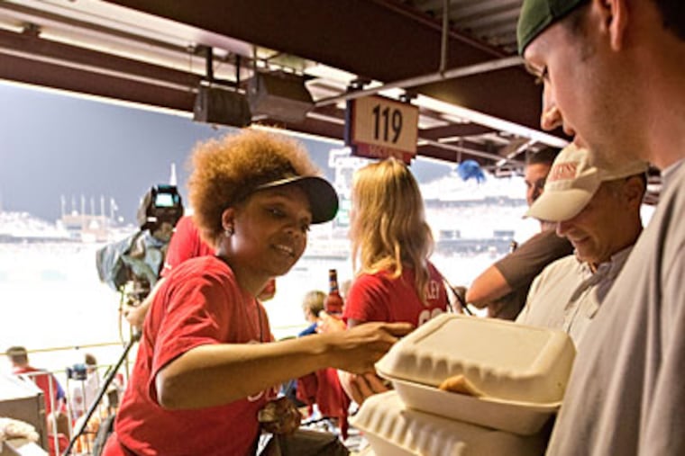Food delivered to his seat, Paul Sandmeyer had his hands full at the Phillies' game Wednesday. (DAVID M WARREN / Staff Photographer)