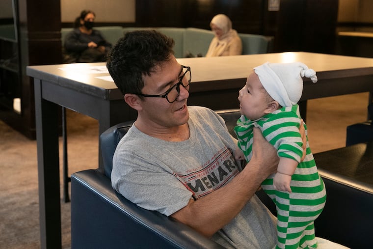 Ghulam Sakhi Danish holds his newborn, Eliana, who was born on Sept. 21 on a U.S. military camp, while sitting in the second floor lobby of the Residence Inn by Marriott Philadelphia Center City on Monday, Nov. 29, 2021. The Nationalities Service Center is taking on the role of resettling two-thirds of the more than 700 Afghan evacuees who will make their permanent homes in Philadelphia. Danish and his family are one of the many families living in the hotel and receiving help from NSC.