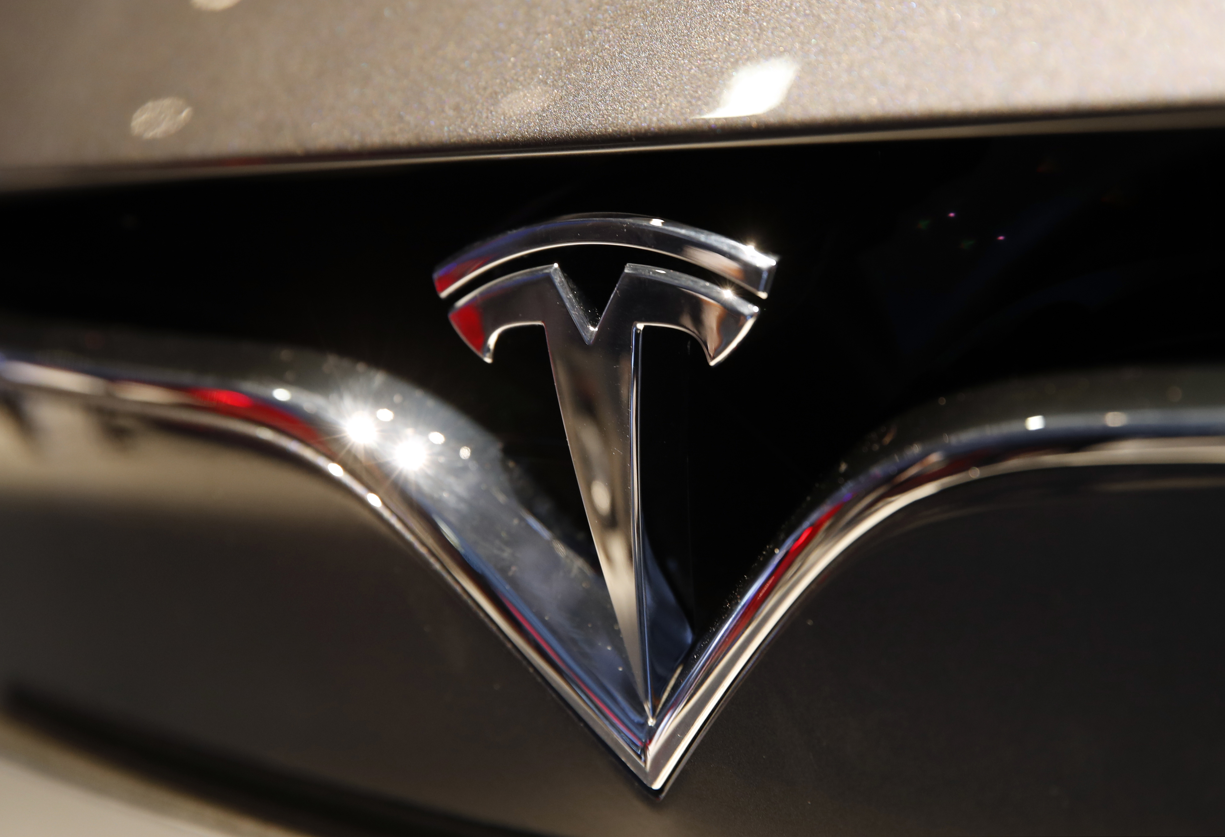FILE - The Tesla logo. Tesla CEO Elon Musk appears poised to transform the company’s electric cars into driverless vehicles in a risky bid to realize a bold vision that he has been floating for years.