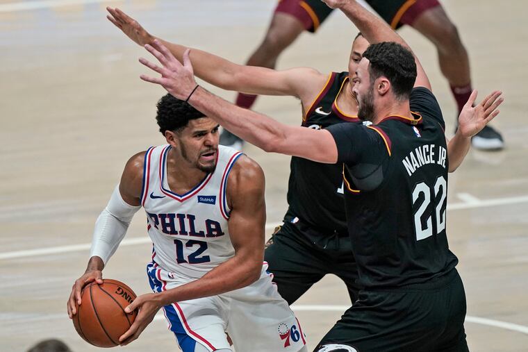 The 76ers' Tobias Harris (12) tries to get past Cleveland Cavaliers' Dante Exum (1) and Larry Nance Jr. in the second half.