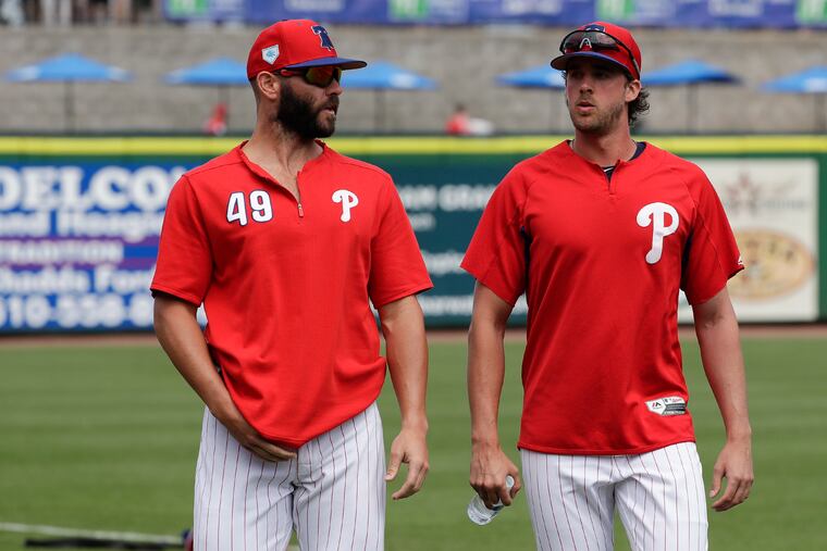 Jake Arrieta (left, with Aaron Nola on Friday) saw his first spring-training action on Sunday.
