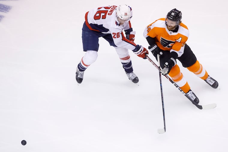 Washington Capitals center Nic Dowd (26) and Flyers center Sean Couturier vie for the puck during the second period.