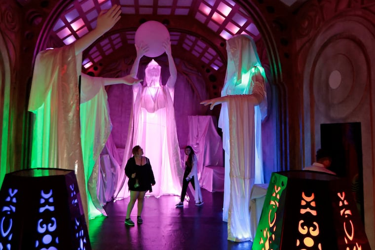 People walk through the warehouse room at the VIP preview of Otherworld, 2500 Grant Ave., on Thursday.