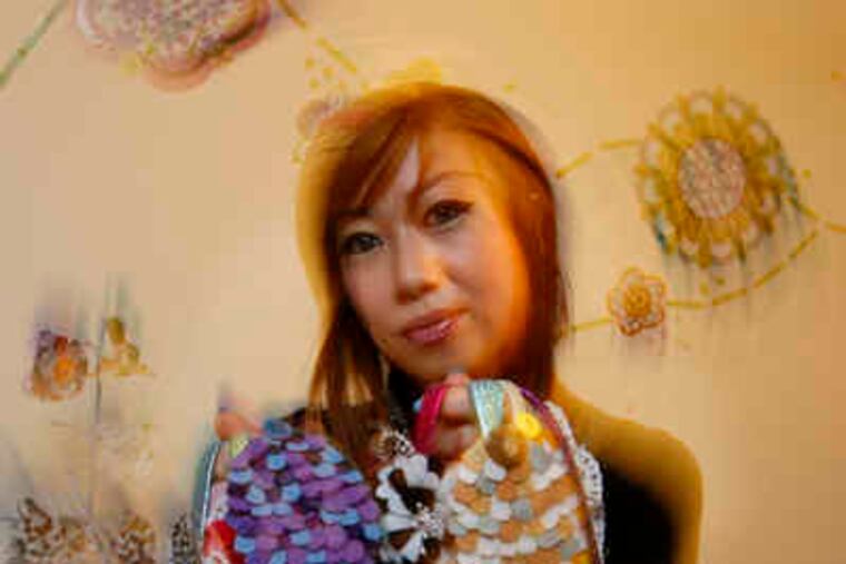 Stephanie Kao with some of her hair accessories, made with materials including feathers, beads, leather, cloth, sequins, and mesh.