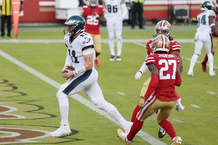 Eagles quarterback Carson Wentz scores a touchdown on an 11-yard option play in the first quarter of Sunday's 25-20 win over the 49ers.