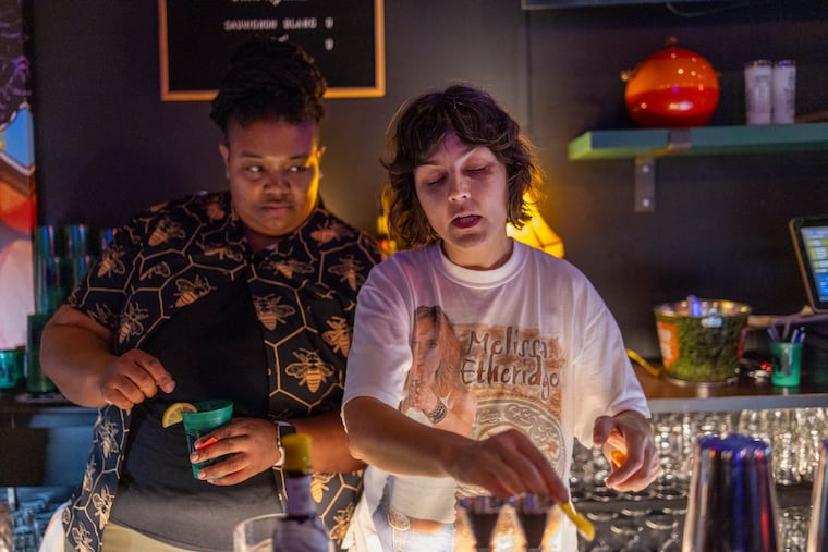 Bartender Whitney Zimmerman (right) serves up cocktails at Marsha's, Philly's first women's sports bar, which opens Friday.