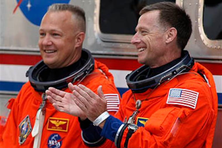 Atlantis commander Chris Ferguson (right), a Drexel grad, applauds with pilot Doug Hurley before leaving the operations and check up building enroute to the pad at the Kennedy Space Center Friday, July 8, 2011, in Cape Canaveral, Fla. Atlantis is the 135th and final space shuttle launch for NASA. (AP Photo / Terry Renna)