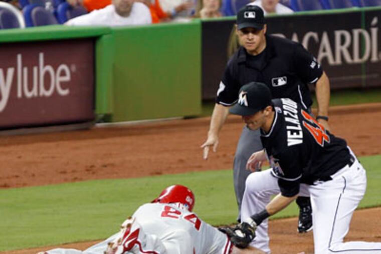 Ty Wigginton is tagged out by Miami Marlins third baseman Gil Velazquez during the third quarter on Friday. (Alan Diaz/AP)