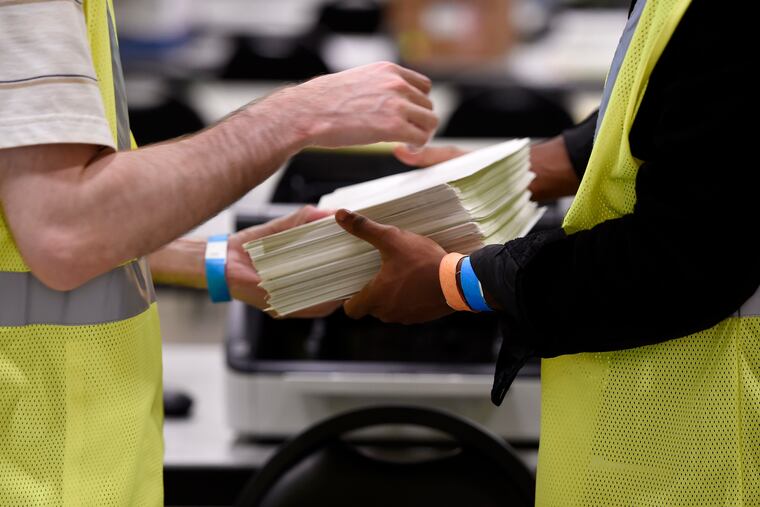 Cobb County Election officials handle ballots during a machine recount, Tuesday, Nov. 24, 2020, in Marietta, Ga. Trump's recent call to Georgia officials alleges shenanigans in the ballot counting but does not specify by whom.