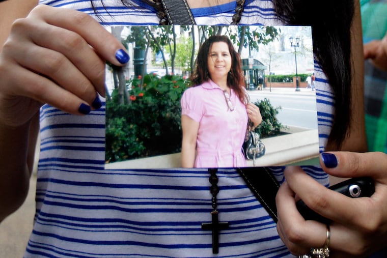 Jessica Nunez, 19, whose parents were the owners of Lorena's Grocery, holds a photo of her aunt, Lina Sanchez, who also was killed in the shooting.
