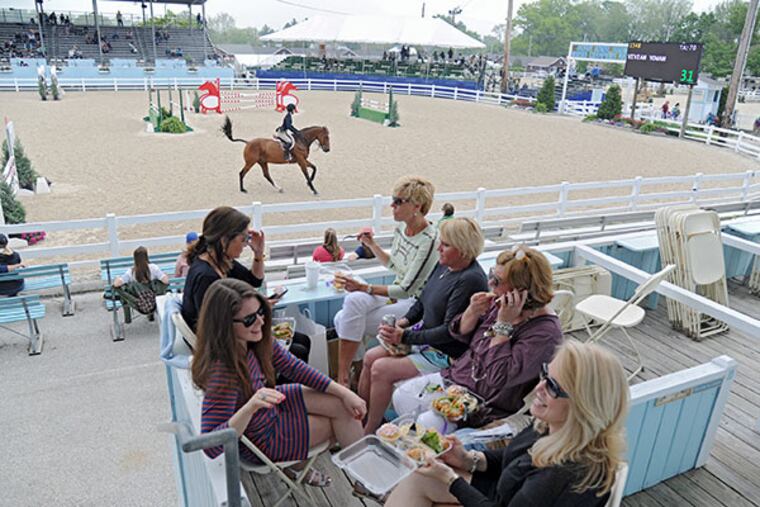 A group of ladies enjoys lunch in the private box of Carol McKiernan (top left of table) as a ride competes in the ring at the 118th annual Devon Horse Show and Country Fair on May 22, 2014. ( CLEM MURRAY / Staff Photographer )