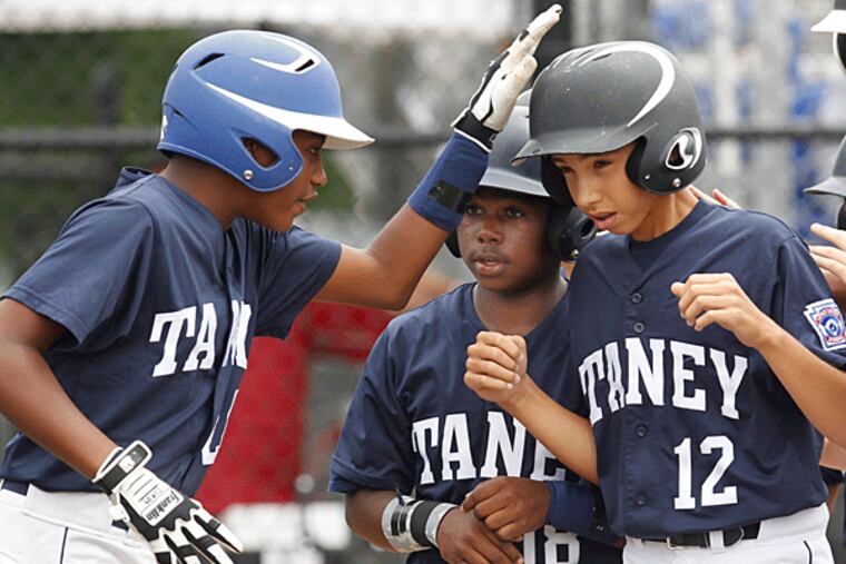 Taney's Jared Sprague-Lott is congratulated by teammates after his two-run home run in the fourth inning. (Ron Cortes/Staff Photographer)