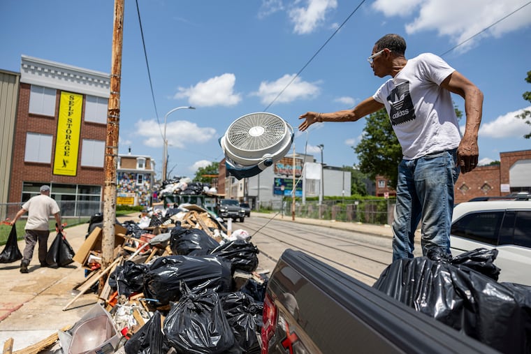 Anthony Sydney, 75, of Germantown, places his trash at a collection site on Tuesday. The drop-off system, while flawed, has merit as a long-term solution, D.R. Hildebrand writes.