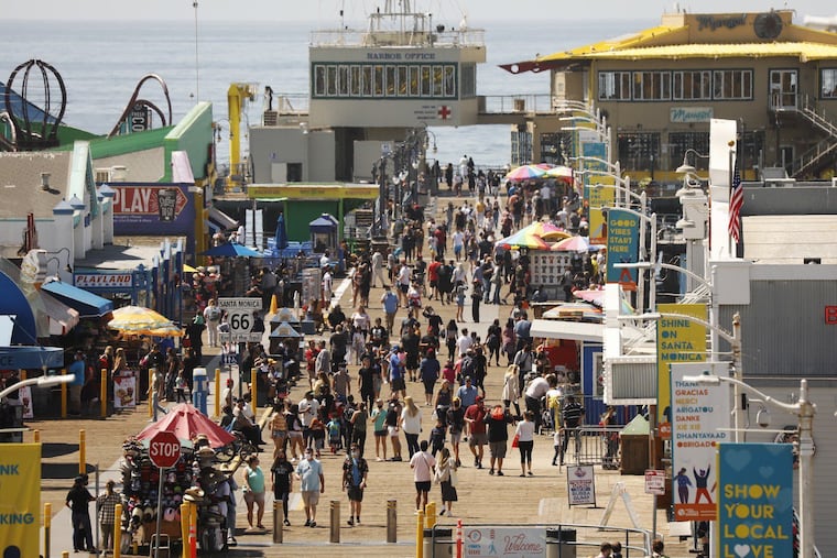 The number of people visiting the Santa Monica Pier ebbs and flows as people take advantage of the warm weather during the spring break in Southern California on Monday.