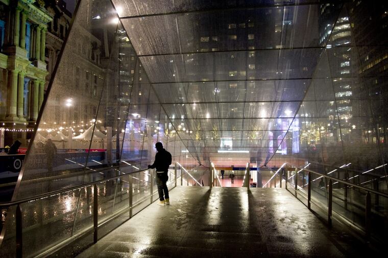 Rain falls on the glass entrance to SEPTA’s underground concourse at Dilworth Park by City Hall. TOM GRALISH / Staff Photographer