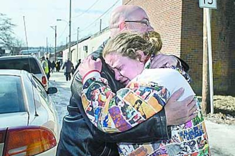 Coatesville neighbors John Wenger and Brandy Hickman embrace near their homes, which were destroyed by a suspected arson fire. (Ed Hille / Staff Photographer)