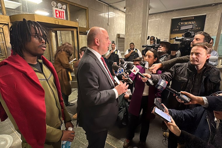 Gusmane Coulibaly (left) listens as his lawyer, George Vomvolakis, speaks to members of the media after Coulibaly's initial court appearance Thursday in New York. He is accused of throwing a snowball at a police officer.