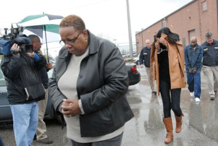 Among those arrested yesterday were Gail Polk (foregound), from whose work computer the counterfeit checks were determined to have been created, authorities allege. (April Saul / Staff photographer)