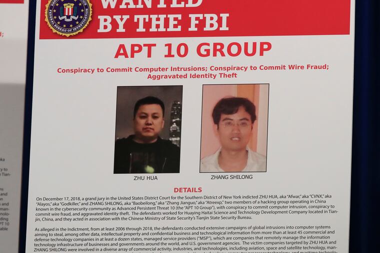 A poster displayed during a news conference at the Department of Justice in Washington, Thursday, Dec. 20, 2018, shows two Chinese citizens suspected to be with the group APT 10 carrying out an extensive hacking campaign to steal data from U.S. companies. The Justice Department is charging two Chinese citizens with carrying out an extensive hacking campaign to steal data from U.S. companies. An indictment was unsealed Thursday against Zhu Hua and Zhang Shillong. Court papers filed in Manhattan federal court allege the hackers were able to breach the computers of more than 45 entities in 12 states. (AP Photo/Manuel Balce Ceneta)