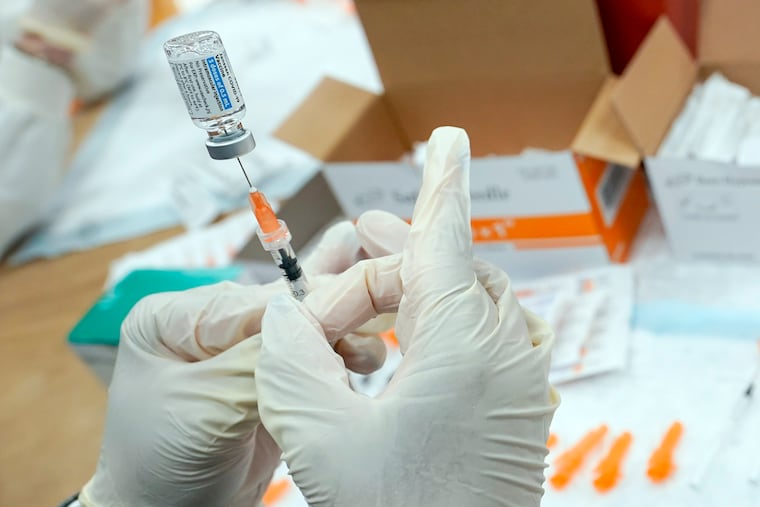 A registered nurse fills a syringe with the COVID-19 vaccine in New York in April 2021.