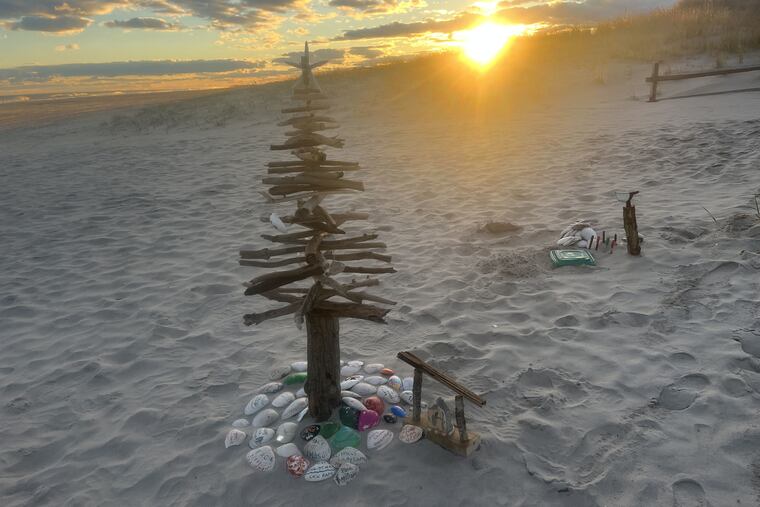 A Christmas tree sculpted of drift wood in the sand at 40th Street in Ocean City, N.J. Beach Christmas trees have proliferated in Jersey Shore towns, most lit with solar lights and often with their own themes.