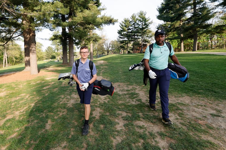 First Tee Greater Philadelphia golfers Dylan Campion (left) and Devin Carpenter walk to the second green at Walnut Lane Golf Club on Thursday.
