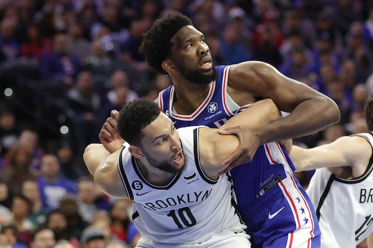 Joel Embiid (top) of the Sixers and Ben Simmons of the Nets get tangled up during the first half Wednesday at the Wells Fargo Center.