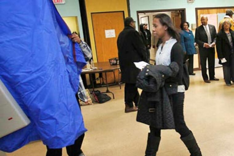 A voter carries her ballot at the John C. Anderson Cultural Center polling place on Tuesday. The "gender gap" may have contributed to Obama's success. ALEJANDRO A. ALVAREZ Staff Photographer