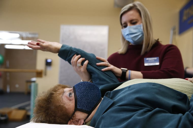 Kimi Smith, a physical therapist at Athletico, works with Joyce Brodsky on strengthening exercises for her shoulder and rotator cuff on Dec. 14, 2020 in Niles, Ill. Brodsky injured her shoulder in September.