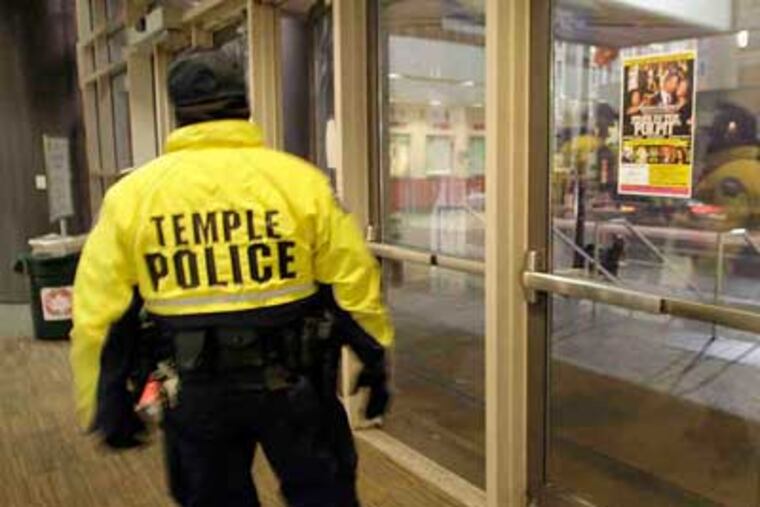 A Temple University police officer patrols outside the Liacouras Center yesterday. The school plans to hire at least 10 police officers and additional security staff.