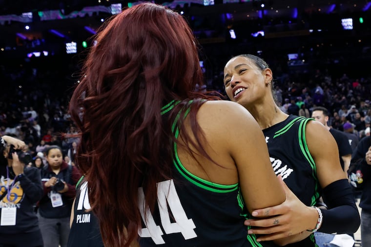 Broomall native Natasha Cloud (right) celebrates the Phantom's 71-68 win over the Breeze with teammate Kiki Iriafen.