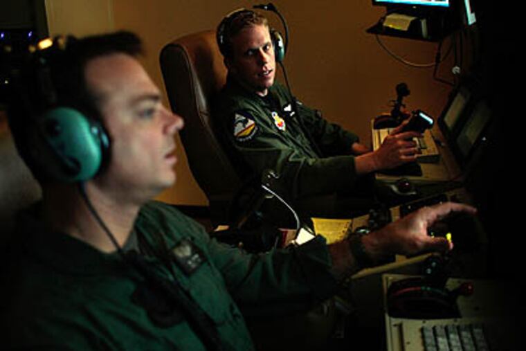 Sensor Operator Tech Sgt. James Jochum and unmanned aerial vehicle (UAV) pilot Capt. Sam Nelson work together from Creech Air Force Base in the Nevada desert while flying a drone remotely over the rough terrain thousands of Afghanistan. (Rick Loomis/Los Angeles Times/MCT)
