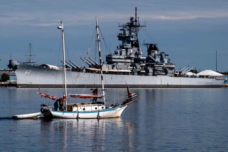 A “peace boat,” the 34-foot wooden ketch Golden Rule, passes the Battleship New Jersey as it arrives at Penn’s Landing Tuesday, May 9, 2023.