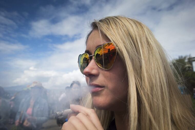 A woman smokes a joint during the annual 4/20 cannabis culture celebration at Sunset Beach in Vancouver, British Columbia, on April 20.