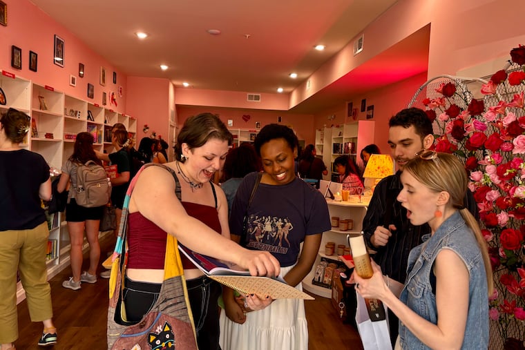 Molly Diane (left) and friends chat about their purchases at Manayunk's Cupid's Bookshop in April.