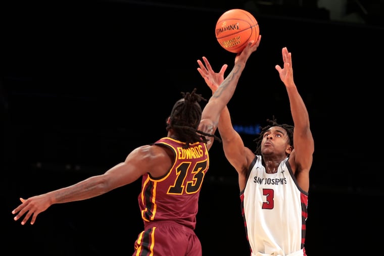 St. Joseph’s guard Cameron Brown, right, battles for a loose ball with Sheldon Edwards of Loyola Chicago during the Atlantic 10 Men's tournament at the Barclays Center on Tuesday.