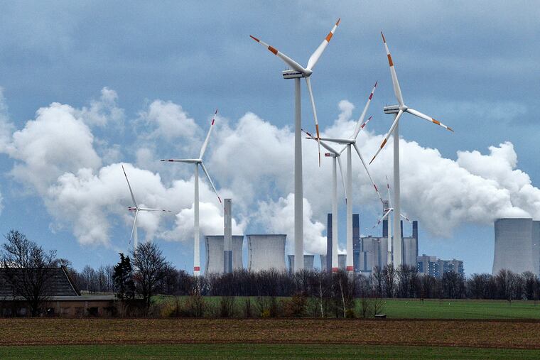 Renewable and fossil-fuel energy is produced when wind generators are seen in front of a coal fired power plant near Jackerath, Germany, Friday, Dec. 7, 2018. (AP Photo/Martin Meissner)