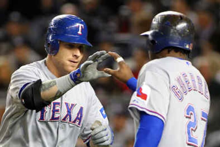 The Rangers' Josh Hamilton gets a hand from Vladimir Guerrero after hitting a two-run homer in the first inning of ALCS Game 3.