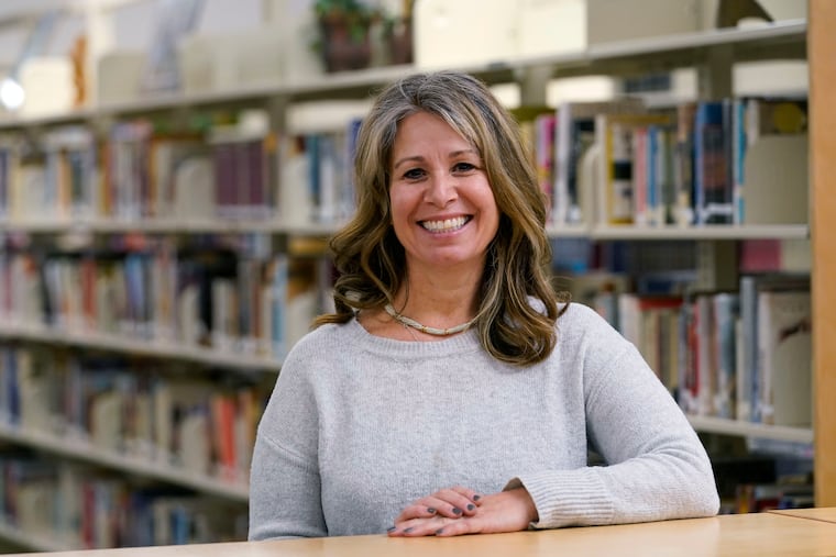 Middle-school counselor Sam Baker poses for a photo in the school's library Wednesday, Nov. 18, 2020, in Sammamish, Wash. A master's degree and a full-time job weren't enough to help Baker land an apartment she could afford in Seattle's east-side suburbs. But a $750 million commitment by a partnership backed in part by Microsoft's affordable housing initiative helped do the trick. Urban Housing Ventures is cutting rents at 40% of the units in three buildings as part of an effort to make sure teachers, nurses and other middle-income professionals can live in the communities where they work. (AP Photo/Elaine Thompson)