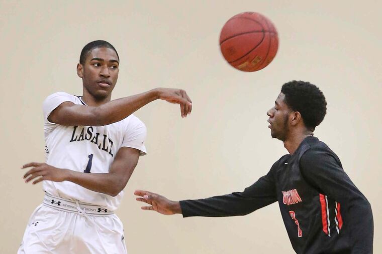 La Salle High School's Allen Powell passes over Constitution's Hakim Hudson (right) in Wyndmoor, Wednesday, December 13, 2017.