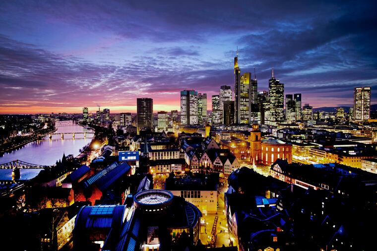 In this Feb. 12, 2019 photo, the sun set over Frankfurt with the buildings of the banking district. Germany, Europe's biggest economy, with companies like Volkswagen, Siemens and BASF, may be entering a recession. In the U.S., 3 of 4 economists surveyed expect a recession by 2021. (AP Photo/Michael Probst, File)