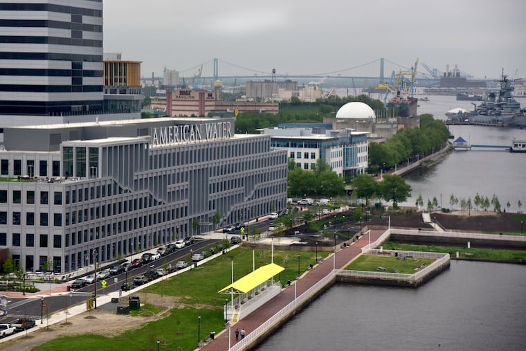 A May 2019 view of the Camden Waterfront shows, at the rear and from the left: One Port Center; the BB&T Pavilion; the Adventure Aquarium; and the Battleship New Jersey. In the center from left to right are the Triad 1828 tower; the corporate headquarters of American Water; and the Ferry Terminal Building.
