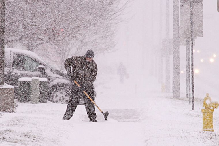 Matthew Kemeny shovels the sidewalk outside the McDonald's restaurant he manages in West Bend, Wis. Snow is expected for the rest of the week. JOHN EHLKE / West Bend Daily News