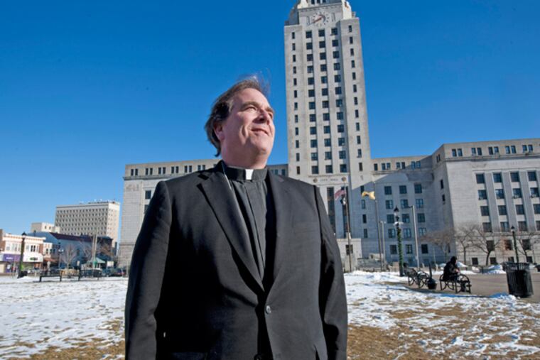Father Jeff Putthoff in the field next to Camden City Hall where the field of crosses was planted in 2012. He was photographed on Dec. 13, 2013. (APRIL SAUL/Staff)