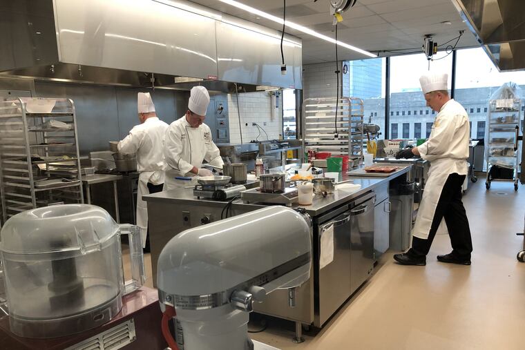 Chefs hustle during the competition in a kitchen at Aramark headquarters at 2400 Market St.
