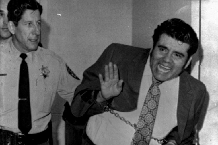 FILE - In this Feb. 5, 1973, file photo, convicted mass slayer Juan Corona waves as he leaves the Solano County Hall of Justice in Fairfield, Calif., after being sentenced to 25 consecutive life terms. California State Prison-Corcoran inmate Corona, 85, died of natural causes on Monday, March 4, 2019, at an outside hospital. Corona was serving 25 concurrent life sentences for 25 counts of first-degree murder. His victims were all farm workers. (AP Photo/File)