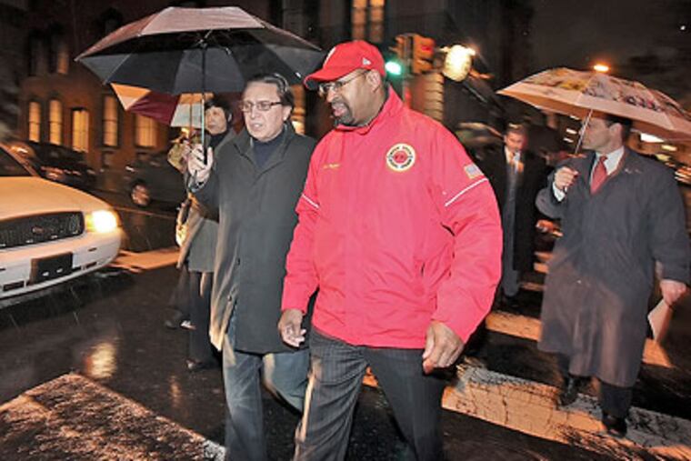 Mayor Michael Nutter and Councilman Frank DiCicco walk in the rain Friday before meeting with store owners/community leaders about issues in Old City on 3rd Street near Arch Street. (Steven M. Falk / Staff Photographer)