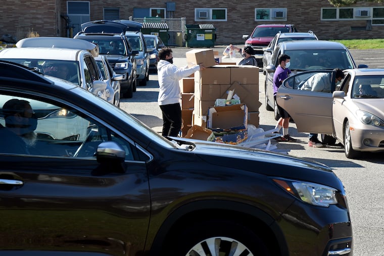 Volunteers load up cars as parents drive through to pick up a week's worth of kosher breakfast and lunch meals in the parking lot of Joyce Kilmer Elementary on Tuesday.