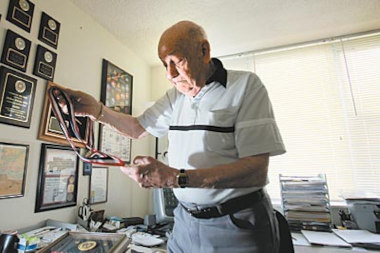 Arthur Seltzer looks over ribbons and medals that he was awarded for his service in World War II. The former Philadelphia resident, who now lives in Cherry Hill, will take the return trip with his wife, Mildred, and a friend. (DAVID SWANSON / Staff Photographer)